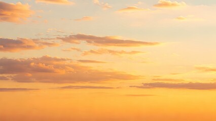 Obraz premium Golden Hour Sky: Soft Pastel Clouds in Hues of Orange, Yellow, and Pale Blue Paint a Tranquil and Warm Scene at Sunset or Sunrise, Evoking Peace and Serenity.