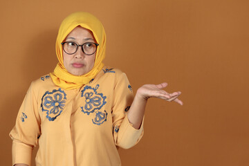 Confused muslim woman shrugging shoulders with expression of uncertainty