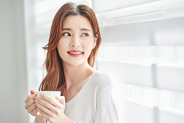 Young Woman Smiling with Coffee Cup Indoors