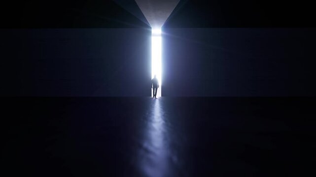 A person walks towards a ray of light in a dark place