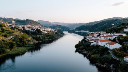 Fototapeta premium Serene river flowing through picturesque village nestled in hills