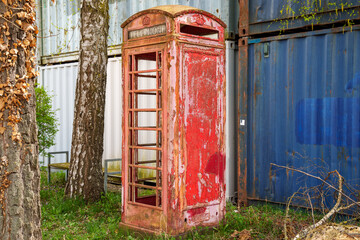 Obraz premium An old, weathered classic red telephone booth of the United Kingdom Post Office from 1924 (type K6)