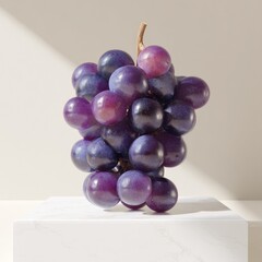 Purple grapes cluster displayed on a white pedestal.
