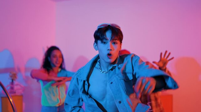 Attractive asian dancer with casual cloth dancing and looking at friend cheering him. Caucasian man and hispanic hipster perform street dancing while turn around and looking at happy team. Regalement.