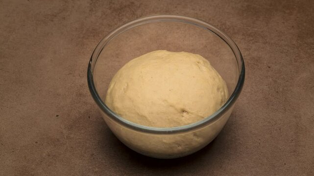 Dough rising in a glass bowl time lapse