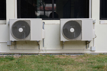 Air compressor or air condenser unit located on support outside building to heat released...