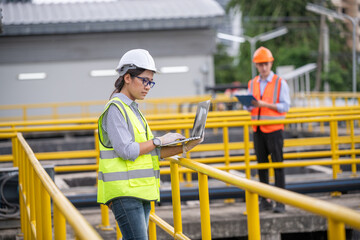 Engineer take water from wastewater treatment pond to check the quality of the water after going...