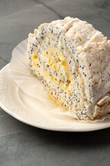 Creamy poppy seed roll dessert served on a white plate with a textured background