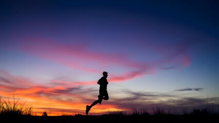 Lone Runner on Scenic Trail at Dusk with Vibrant Sunset Sky in Deep Blue Orange and Pink Dramatic Lighting High Dynamic Range 4K Cinematic Scene