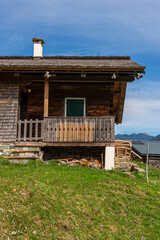 Curved countryside path framed by green hills and bare spring trees with mountains rising in the background.