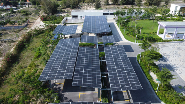 Aerial view of solar power plant with blue photovoltaic panels mounted on parking garage. Production of sustainable energy concept