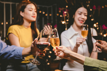 Happy young friends celebrate together at a stylish restaurant, enjoying wine, laughter, and friendship during an elegant evening gathering.