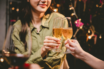 Happy young friends celebrate together at a stylish restaurant, enjoying wine, laughter, and friendship during an elegant evening gathering.