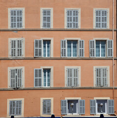 Fototapeta premium typical facade of an old hotel with open and closed wooden shutters