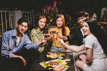 Diverse group of friends joyfully toast with wine and champagne, celebrating success, togetherness, and happiness at an elegant festive gathering.