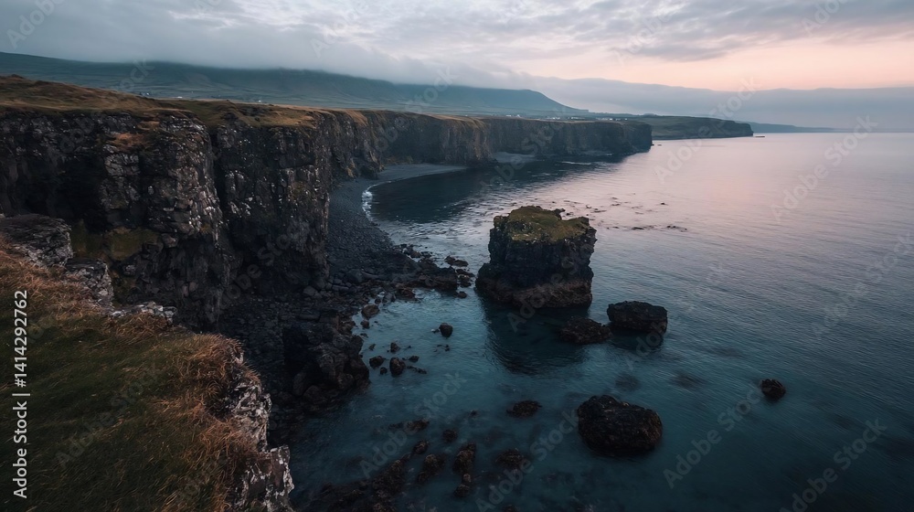 Poster Coastal landscape with rugged cliffs meeting calm waters under a dusky sky creating a serene atmosphere. Rocky foreground and distant hills adds depth and scale