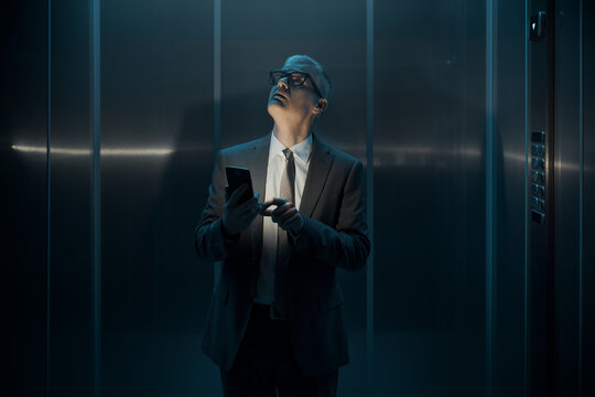 Worried businessman stuck in the lift