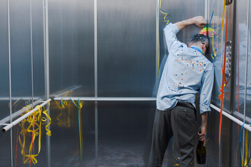 Sad office worker celebrating alone in the elevator
