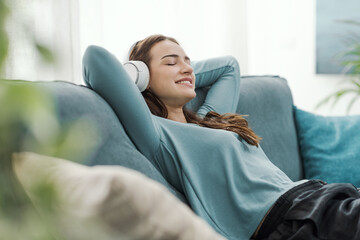 Woman relaxing on the couch and listening to music