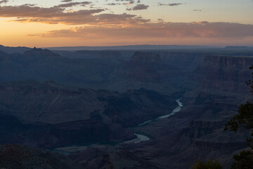 Sunset over the Grand Canyon showcasing dramatic rock formations and winding river in Arizona