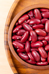 Raw red kidney beans in wooden bowl. Top view
