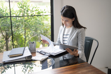 Happy young Asian Woman Successful Business woman creative using digital tablet  in office