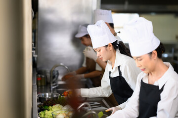 Cooking school students preparing fresh ingredients during class