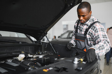 Skilled mechanic technician working at service station, repairing car
