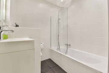 Sleek and minimalist bathroom featuring a glass shower, modern fixtures, and neutral tones that create a serene atmosphere.