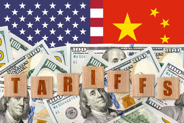 Dollars on a US and China flags background with word TARIFFS. Trade, duty, customs and tariffs war