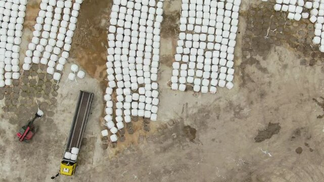 Construction equipment loading on a truck. Beet pulp packages are loaded onto a truck at the sugar factory. animal feed packages. Top view. 