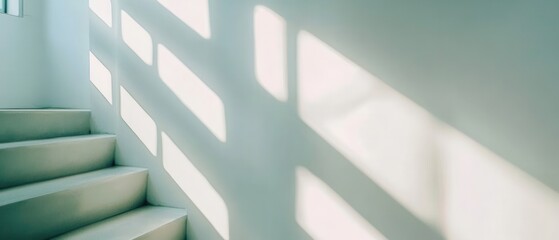 Fototapeta premium Modern staircase bathed in light casting geometric shadows on a pale wall creating a serene and minimalist architectural scene with a clean aesthetic
