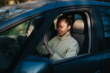 A woman sits in her car, looking overwhelmed and emotional, possibly due to vehicle issues. Her...