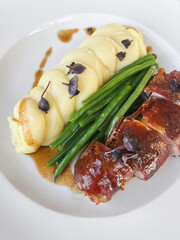 Bacon Wrapped Turkey Breast Roulade served with mashed potato and green beans