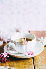 Décor aux couleurs douces pastel rose avec une tasse de thé et un petit lapin de pâques adorable