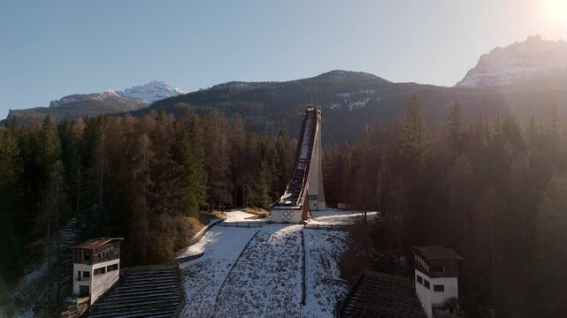 Aerial for ski jump in cortina d'Ampezzo Dolomite winter sport travel destination drone at sunset