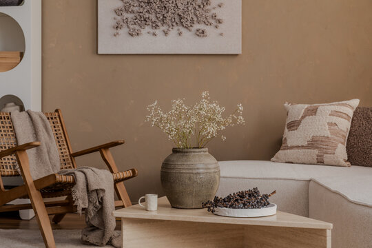 Natural-toned interior with rustic vase, textured pillows, and cozy lounge chair in a calm neutral palette...