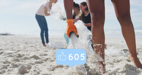 Image of falling social media like icons over diverse women picking up rubbish from beach