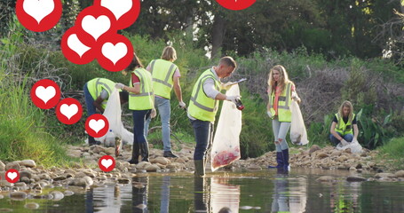 Image of red hearts over diverse group picking up rubbish by river in countryside