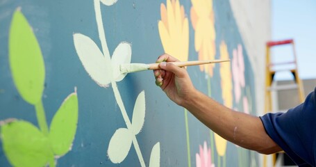 Man, hand and painting in city for wall art, creative mural and project to uplift community....