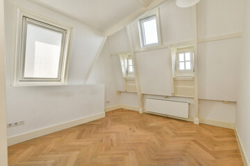 Fototapeta premium Bright, airy room featuring stylish triangular windows and a warm wooden floor, ideal for relaxation or work. The minimalist design enhances the spacious feel.