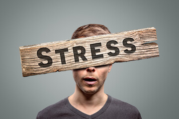 Wooden stress sign in front of a person's face 