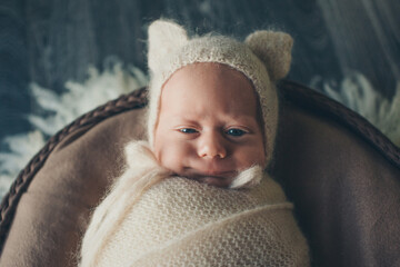 A newborn baby is wrapped in diapers with a wool cap in a basket. Swaddling, maternity hospital, family, ivf, life planning, parenting. A mother's love for her child. Baby food. High quality photo