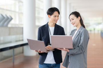 オフィスで会議をする若い男女のエンジニア