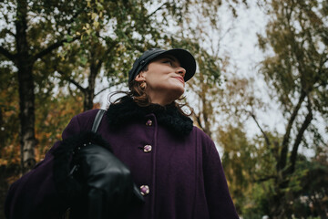 A woman dressed fashionably outdoors on a calm, overcast day, surrounded by lush greenery, exuding...