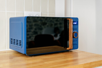 Modern kitchen with blue microwave and wooden accents for stylish cooking
