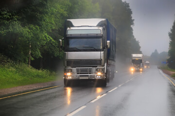 Large trucks drive in the rain