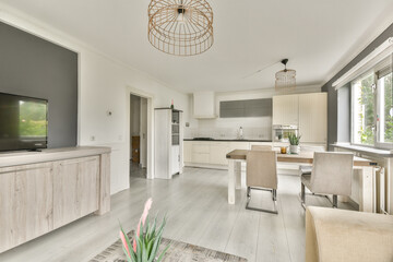 A stylish modern kitchen and living area featuring minimalist decor, elegant lighting, and a light color palette that promotes an open and airy feel.