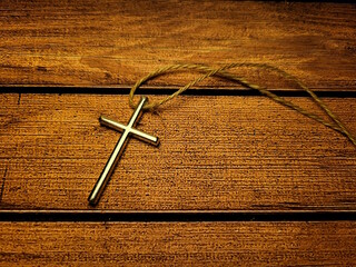Metal Christian Cross Pendant on Wooden Table – Faith and Spiritual Symbol