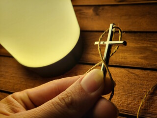 Hand Holding Christian Cross Pendant – Symbol of Faith and Devotion